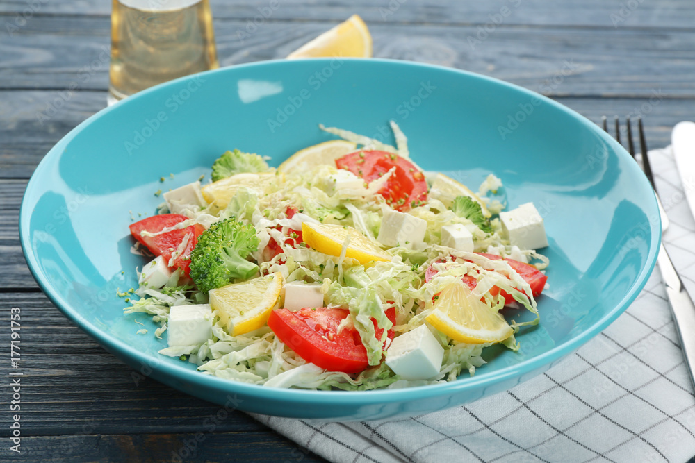 Plate with tasty vegetable salad on wooden table Plate with tasty vegetable salad on wooden table