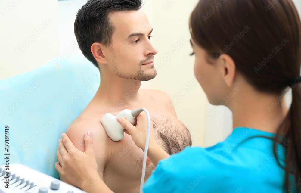 Φωτογραφία Doctor conducting ultrasound examination of patient's shoulder in clinic