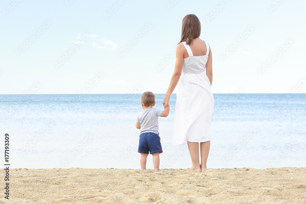 Happy mother with little son on beach
