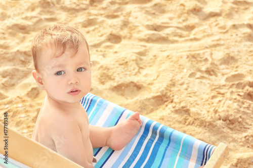 Little boy sitting on beach...