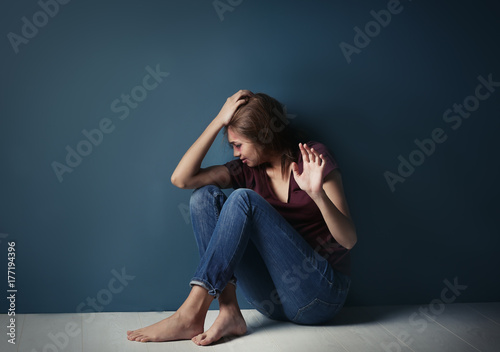 Battered young woman sittin...