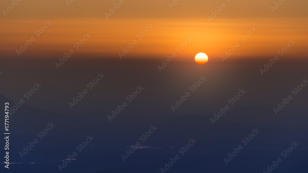 Sunset hot yellow and red sky. Sun is hidding behind clouds. Sunset hot yellow and red sky. Sun is hidding behind clouds.