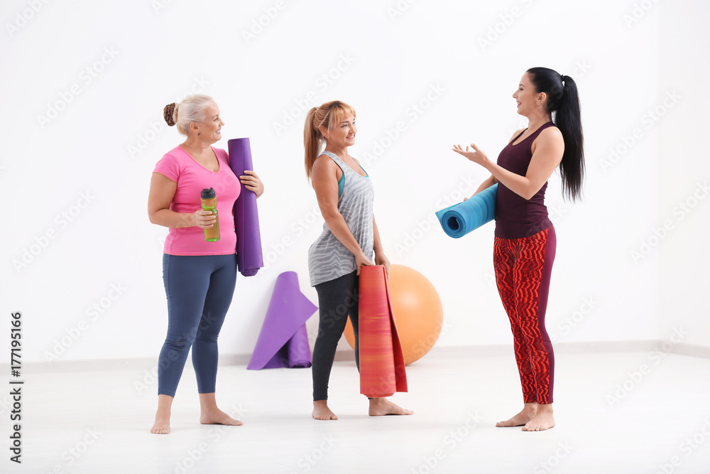 Fototapeta premium Women with yoga mats indoors