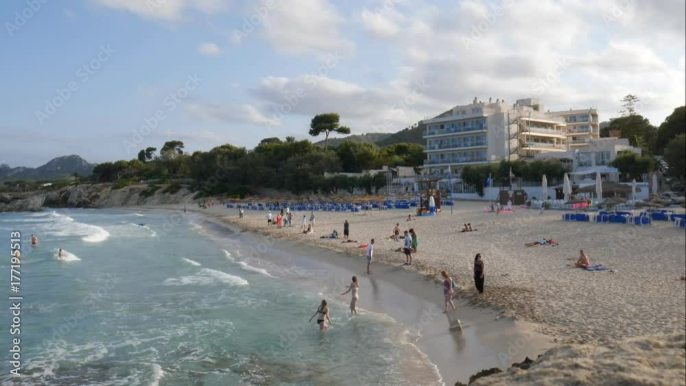 Tourists swimming at the Son Moll beach in the evening in Cala Ratjada Mallorca Spain Tourists swimming at the Son Moll beach in the evening in Cala Ratjada Mallorca Spain