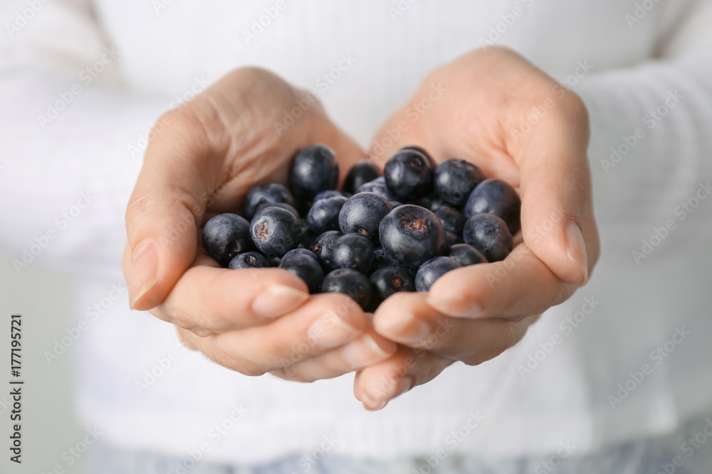 Woman holding fresh acai berries, closeup Woman holding fresh acai berries, closeup