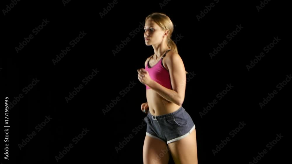 Athlete in sports clothes running lightly on a black screen. Close up Athlete in sports clothes running lightly on a black screen. Close up