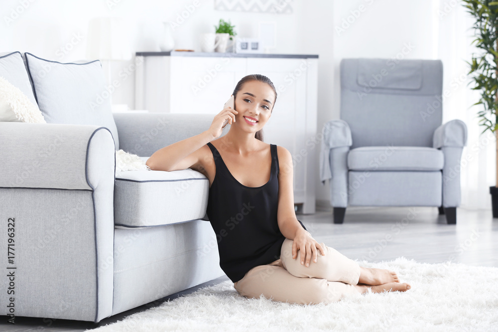 Beautiful young woman speaking by mobile phone at home Beautiful young woman speaking by mobile phone at home