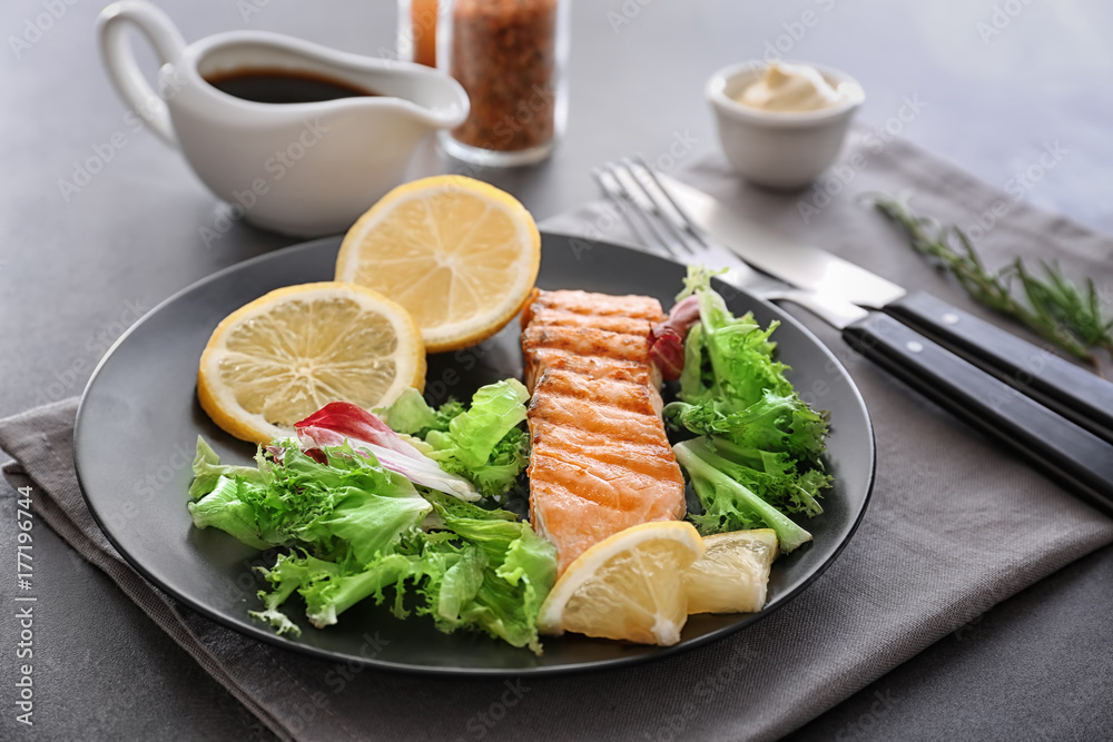 Plate with slice of delicious salmon on table Plate with slice of delicious salmon on table