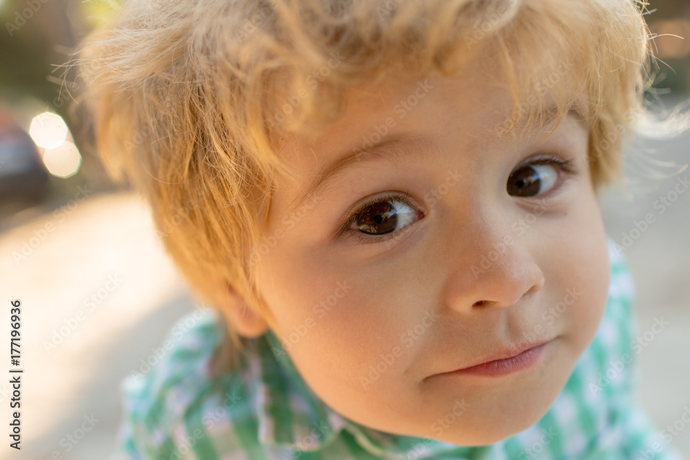 Funny face portrait child close up. Face of sweet cute child, boy looks at camera, emotionate expression, open eyes, interested kid. 3 year old blond boy learns knows something new. Boy explores world