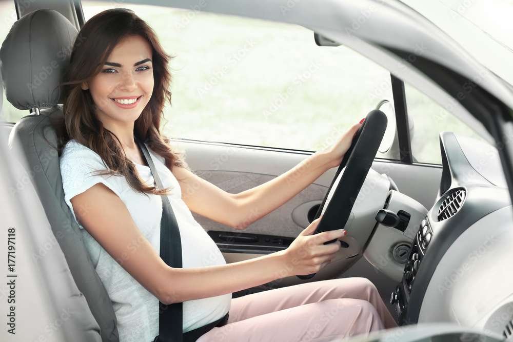 Pregnant young woman driving car Pregnant young woman driving car