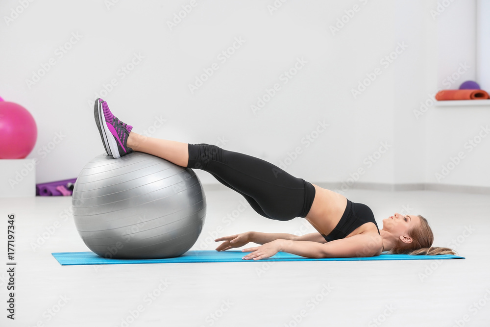 Beautiful young woman with fitness ball training in gym Beautiful young woman with fitness ball training in gym
