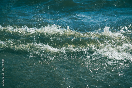 Fototapeta Naklejka Na Ścianę i Meble -  Small waves on the sea shore on a sunny day