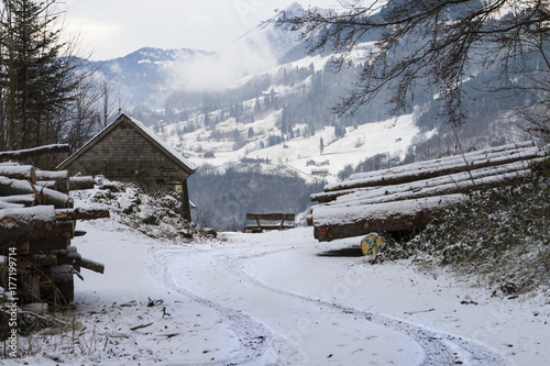 TIMBER FARMER BARN HOUSE IN WINTER MOUNTAIN SNOW COVERED LANDSCAPE IN OBERSEE, SWITZERLAND