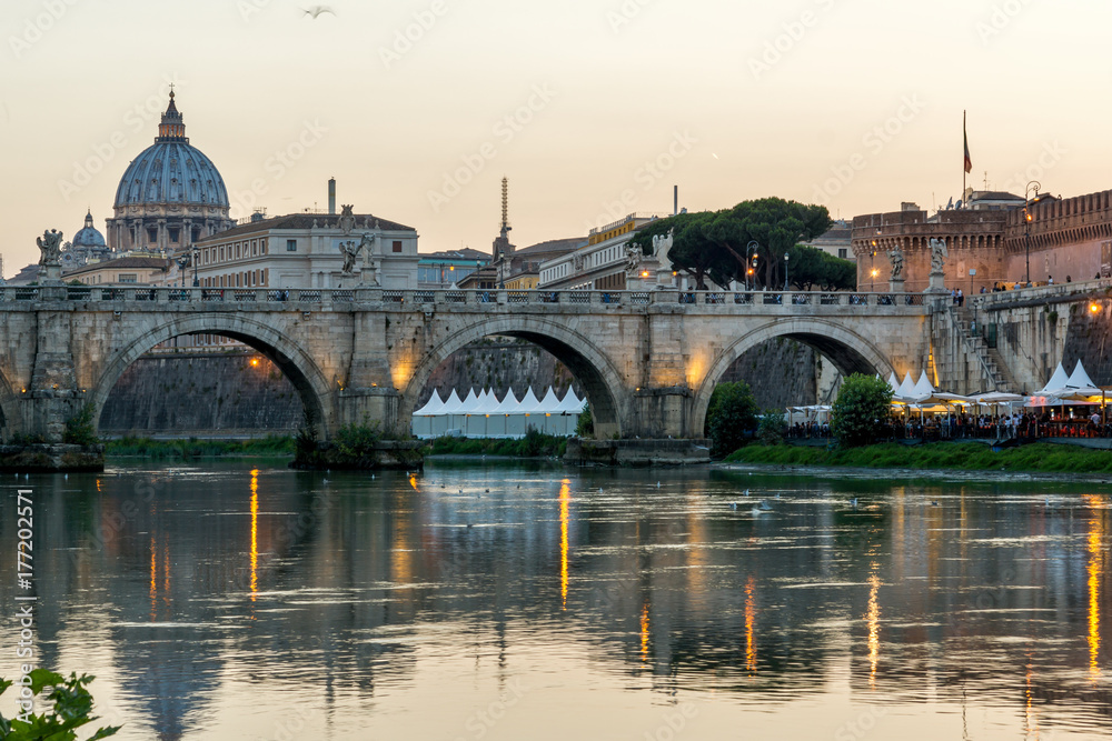 ROME, ITALY - JUNE 22, 2017: Amazing Sunset view of Tiber River, St. Angelo Bridge and St. Peter's Basilica in Rome, Italy