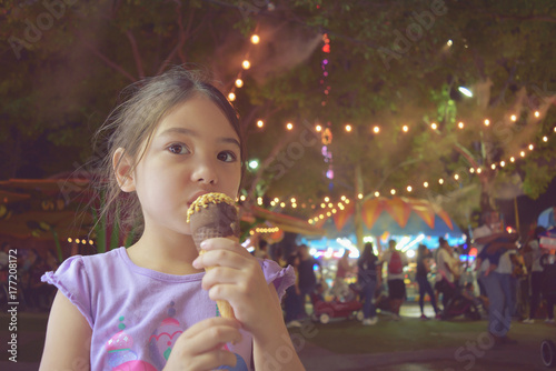 little girl having ice cream at state fair, filtered tones