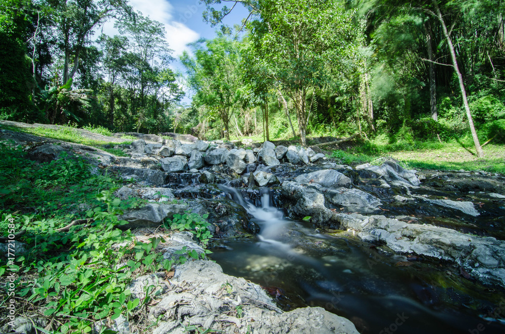 A small little waterfall falling on a small lake in Thailand A small little waterfall falling on a small lake in Thailand