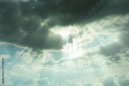 Nature background.The sun shines down from the sky, where the black cloud is covered.