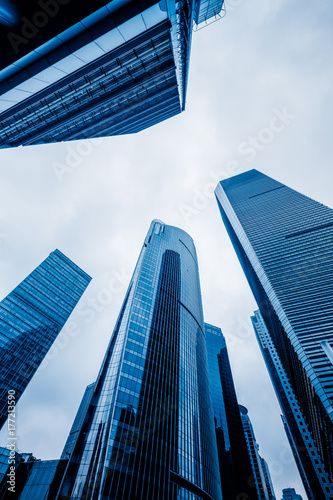 Bottom view of modern skyscrapers in business district against blue sky.