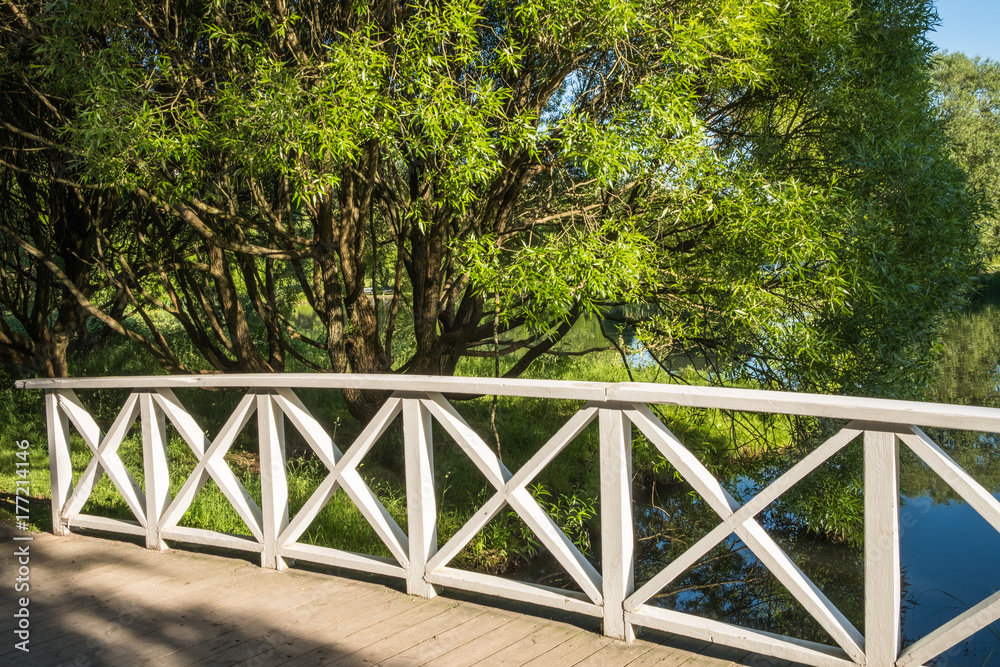 Detail of a wooden bridge with white painted rail in a park Detail of a wooden bridge with white painted rail in a park