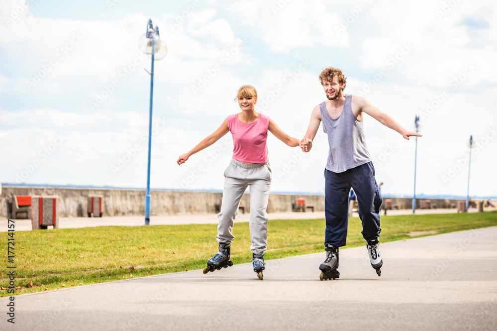 Fototapeta premium Active young people friends rollerskating outdoor.