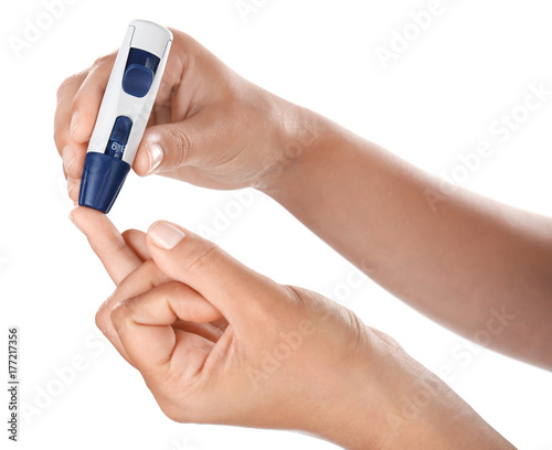 Woman taking blood sample with lancet pen on white background. Diabetes concept