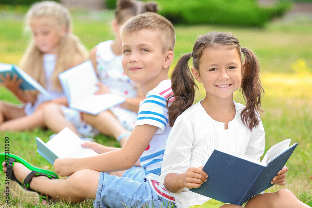 Cute little children reading books in park Cute little children reading books in park