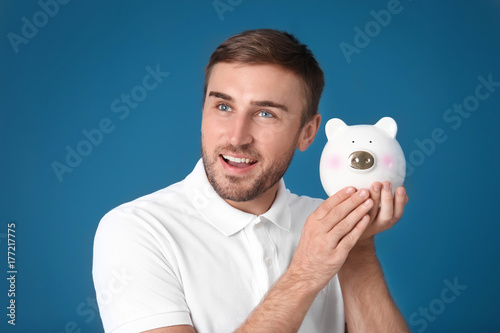 Young man with piggy bank o...