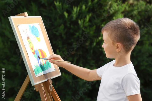 Cute little boy painting pi...