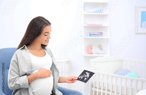 Pregnant woman looking at u...