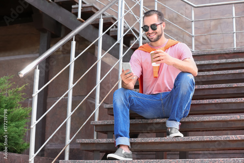 Man with smartphone and cup...