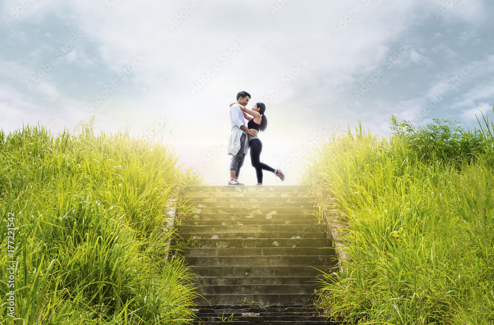 Young couple hugging on upstair at forest trail after workout - fitness, sport, healthy, lifestyle and lover relationship concepts. Young couple hugging on upstair at forest trail after workout - fitness, sport, healthy, lifestyle and lover relationship concepts.