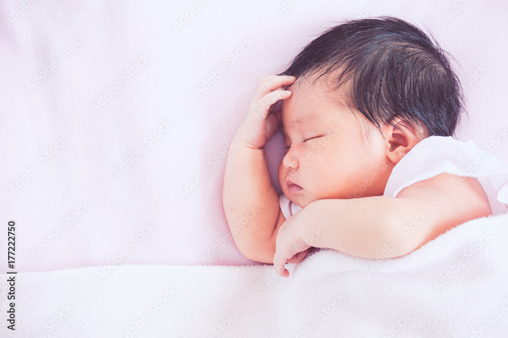 Cute asian newborn baby girl sleeping in bed with pink blanket Cute asian newborn baby girl sleeping in bed with pink blanket
