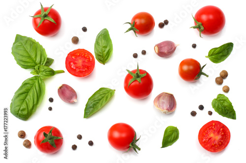 mix of slice of tomato, basil leaf, garlic and spices isolated on white background. top view
