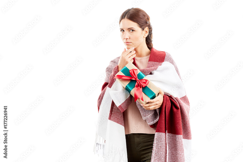 Portrait of woman wrapped in blanket holding Christmas gift Portrait of woman wrapped in blanket holding Christmas gift