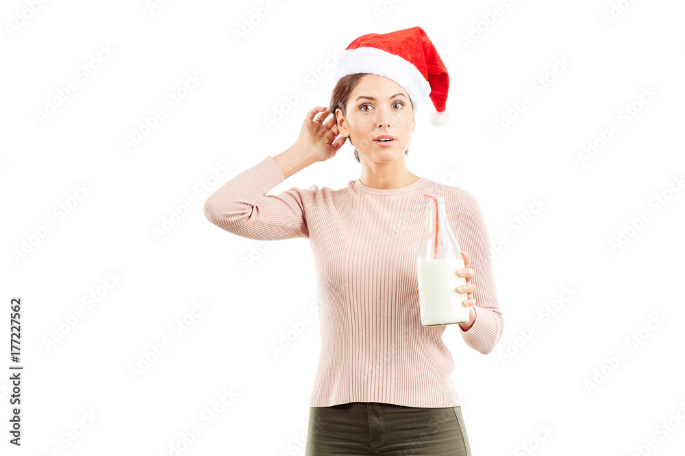 Portrait of woman in Santa hat holding bottle of milk on white background Portrait of woman in Santa hat holding bottle of milk on white background