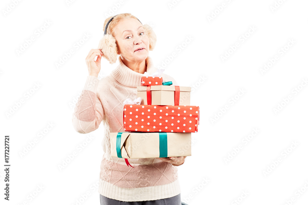 Portrait of senior woman in earmuffs holding heap of Christmas gifts Portrait of senior woman in earmuffs holding heap of Christmas gifts