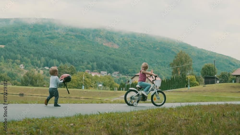 Little cute girl and her younger brother in the nature by the lake. Little cute girl and her younger brother in the nature by the lake.