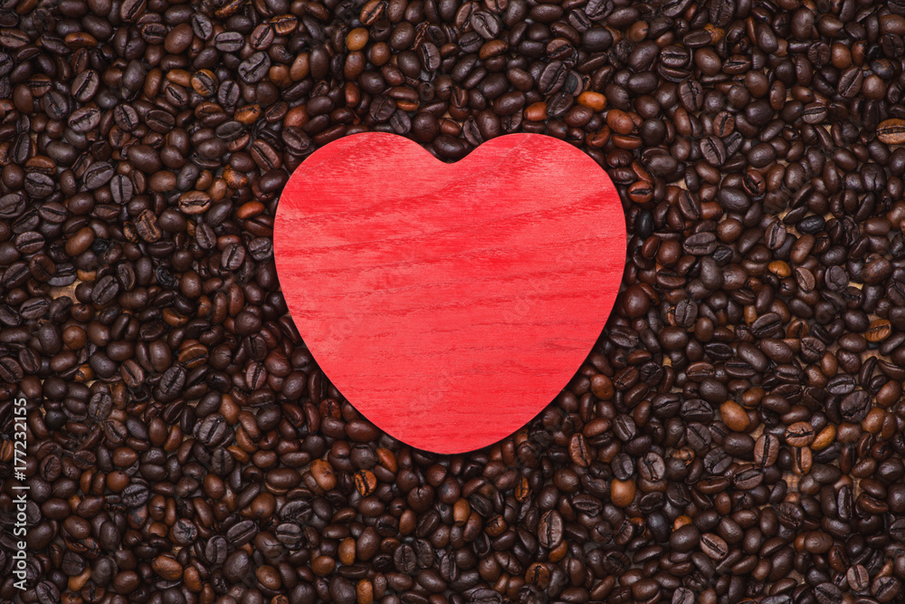 Red wooden heart shape on coffee beans background. Red wooden heart shape on coffee beans background.