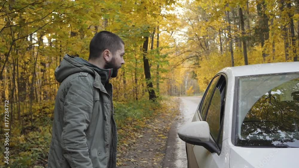 Young man hitchhiker with standing on a highway in autumn. Adventure and tourism concept Young man hitchhiker with standing on a highway in autumn. Adventure and tourism concept