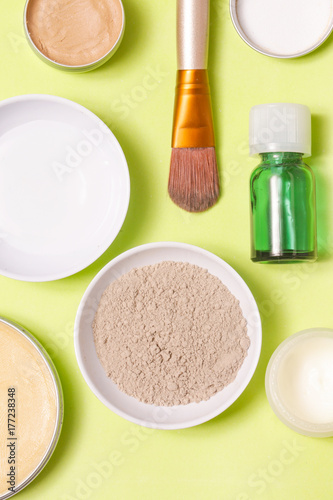 Top view of different cosmetics products on yellow background