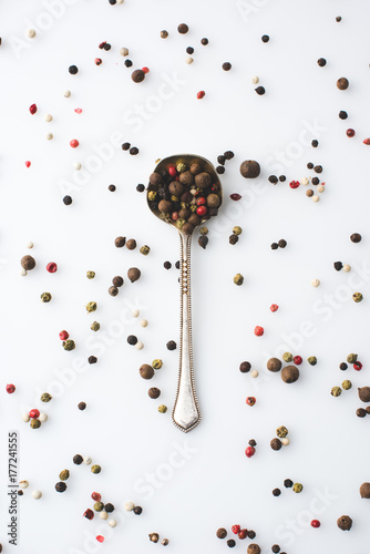 spoon with spilled peppercorns