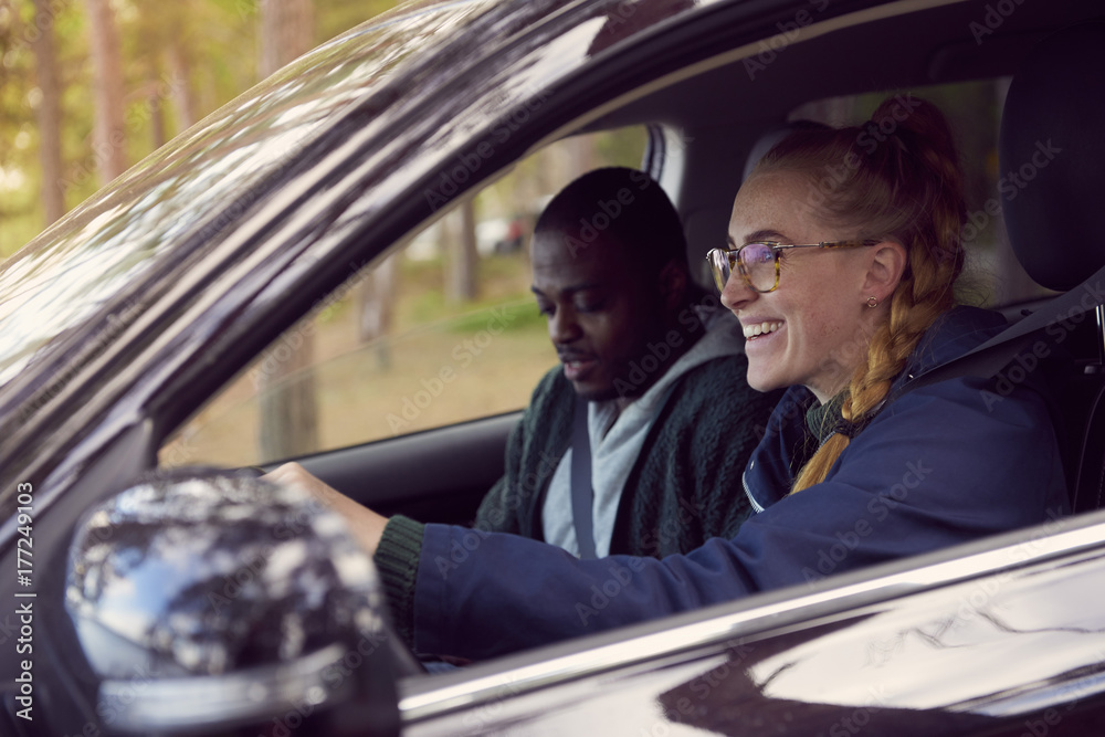 Smiling woman driving car while sitting with man Smiling woman driving car while sitting with man