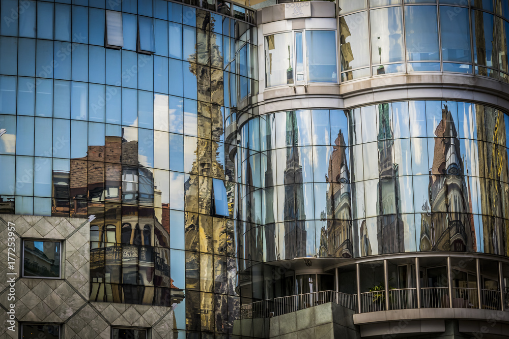 Reflection of houses in glass window of modern building. Modern office building exterior, old houses reflected on the glass of a curtain wall.