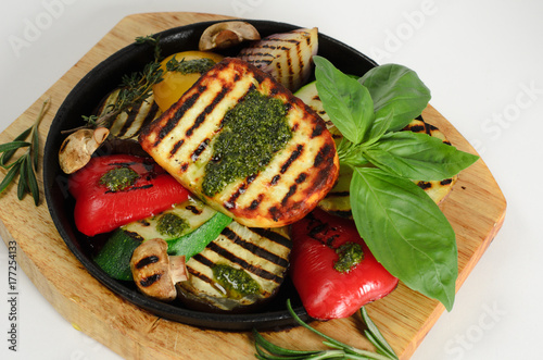 Vegetables grilled with cheese in a pan on a wooden desk