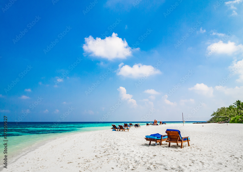 Tropical island vacation image, white sand beach and sun beds Tropical island vacation image, white sand beach and sun beds