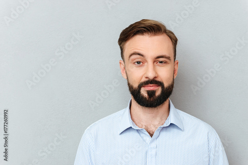 Quizzical bearded man in business clothes looking at the camera