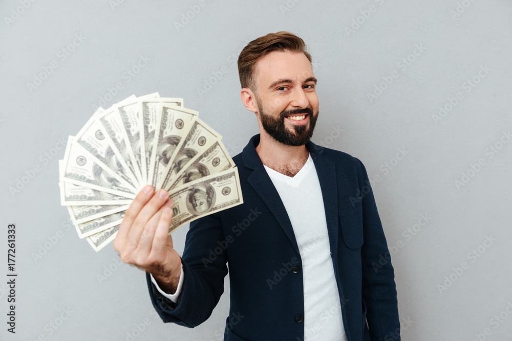 Pleased bearded man in business clothes showing money Pleased bearded man in business clothes showing money