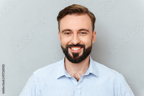 Happy bearded man in business clothes looking at the camera