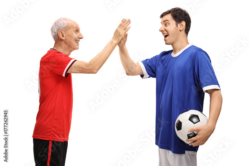 Old footballer and a young footballer high fiving