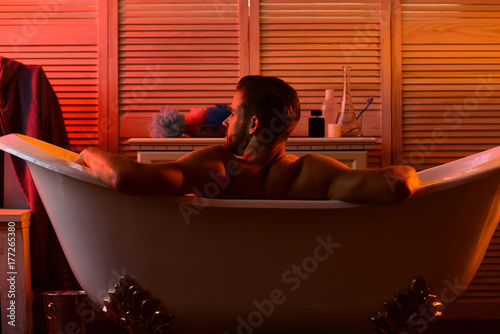 Back of macho enjoying bath with romantic light around